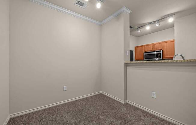 A room with a kitchenette in the corner.