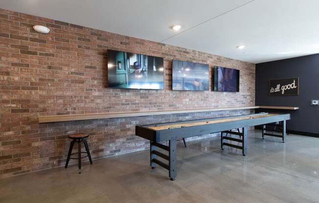 a game room with a shuffleboard table and a bar