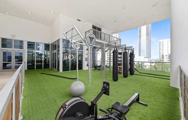 a gym with grass and weights on the floor and a view of the city