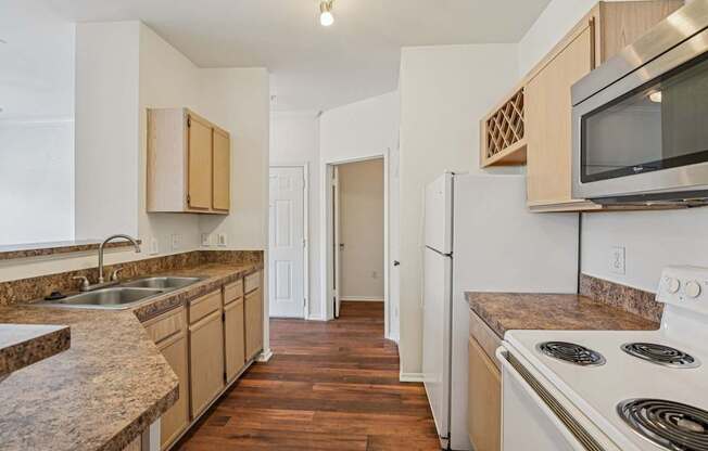 A kitchen with white appliances and wooden cabinets