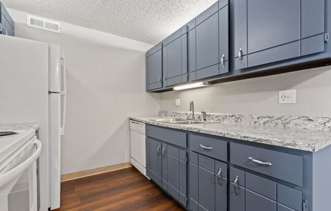 a kitchen with blue cabinets and a white refrigerator