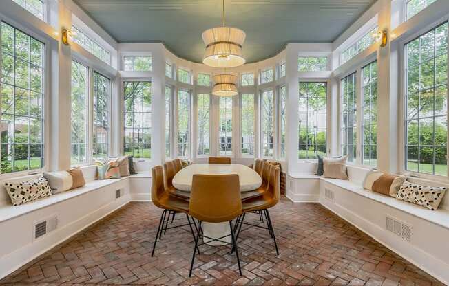 a dining room with a table and chairs and windows