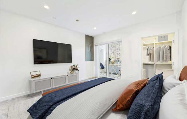 A modern living room with a grey sofa and a flat screen TV mounted on the wall.