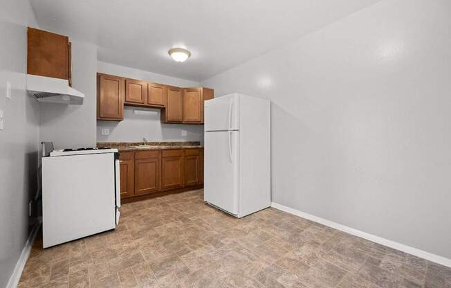 A kitchen with a white refrigerator and a white dishwasher.
