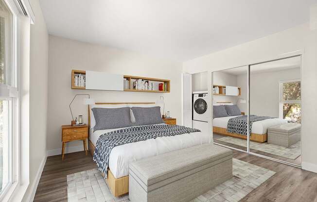 A bedroom with a large bed and a mirrored closet door.