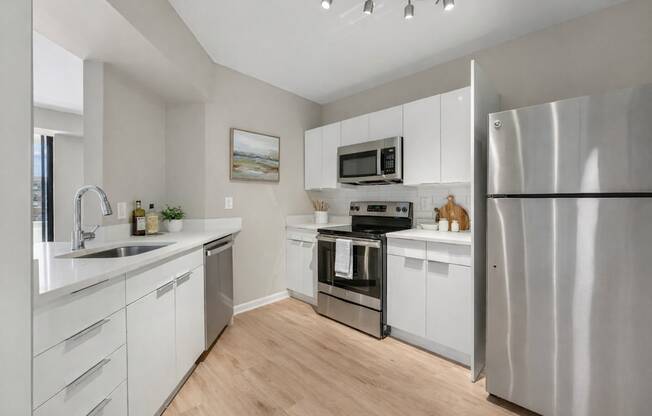 An upgraded modern kitchen with stainless steel appliances and white cabinets.