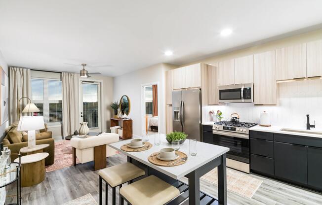 An open-concept apartment home with a central island, streamlined kitchen, and connected living areas designed for everyday flow and flexibility.