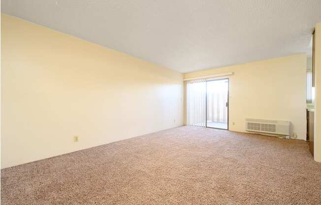 an empty living room with a door leading to a balcony at Park Columbia Apts, Hemet California