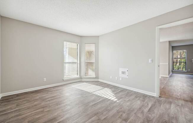 A room with wooden flooring and a door leading to a balcony.