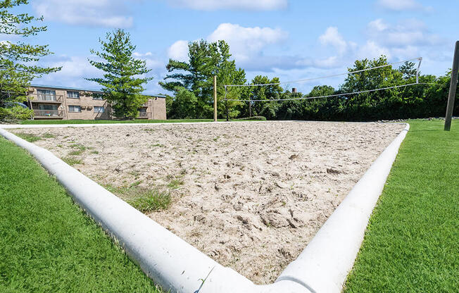 a sand pit in the middle of a grass field