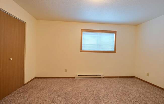 an empty room with a door and a window. Fargo, ND Kennedy Apartments