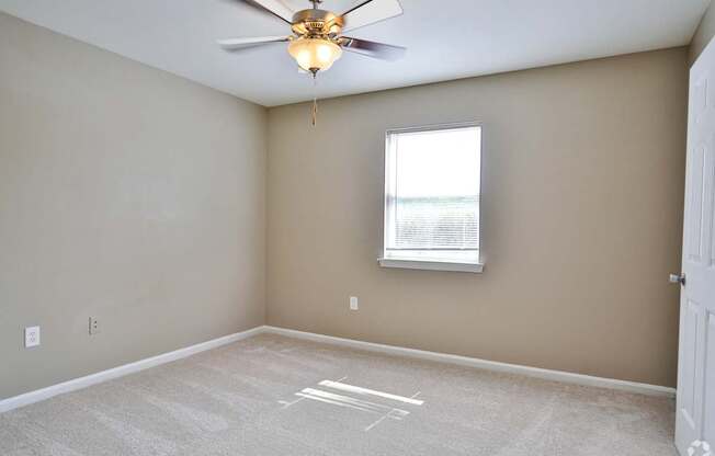 A room with a ceiling fan and a window.