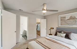 a bedroom with a large bed and a ceiling fan
