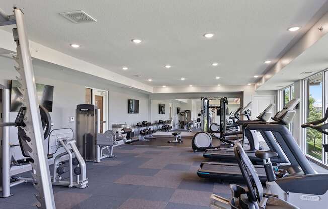 a gym with various cardio machines and weights