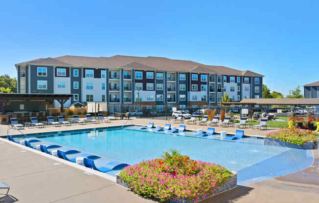 A large hotel with a pool in front.