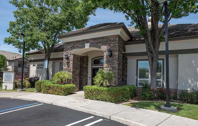 A clubhouse with a stone archway entrance and a sign at Stoneridge Apartments, California, 95661