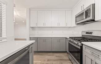 A kitchen with white cabinets and a stainless steel oven.