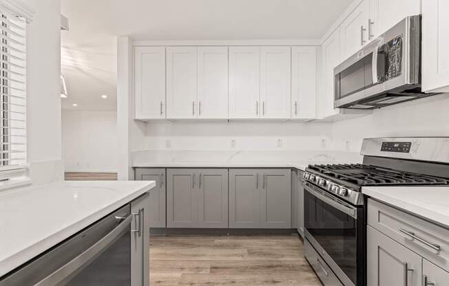 A kitchen with white cabinets and a stainless steel oven.