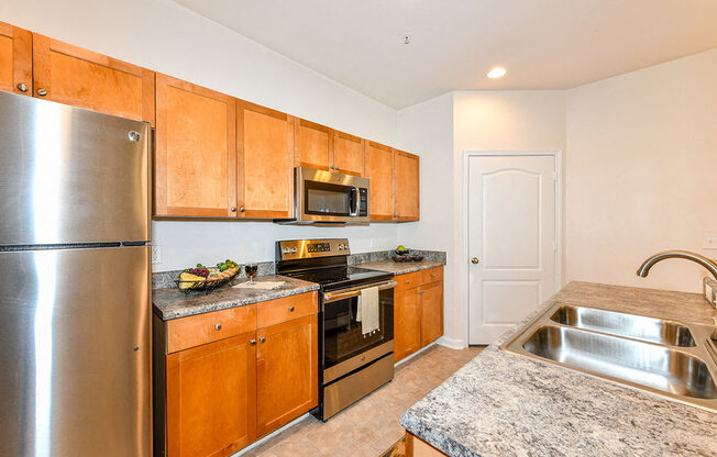 Open Kitchen with Custom Maple Cabinets, Stainless Steel Appliances and Breakfast Bar at Alden Place at South Square Apartments, Durham, NC 27707