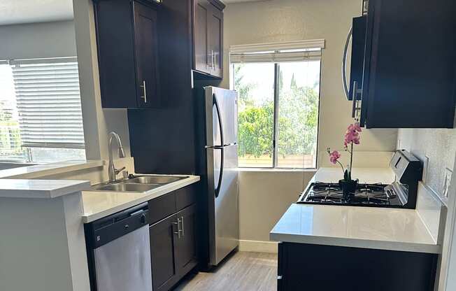 A black television is mounted on a wall above a black drawer.