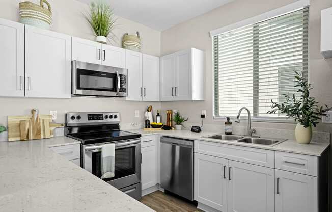 a modern kitchen with white cabinets and stainless steel appliances