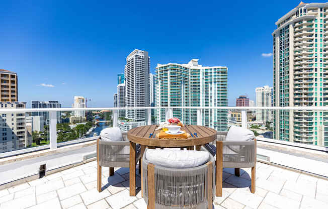 a balcony with a city view and a table and chairs