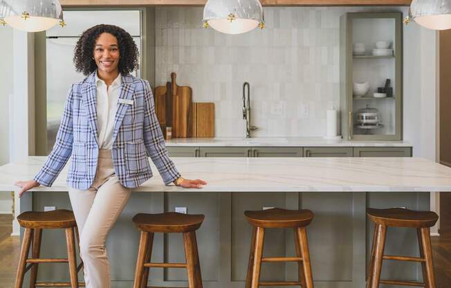 a woman sitting on a counter in a kitchen