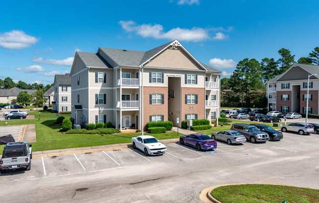 an apartment building with cars parked in a parking lot