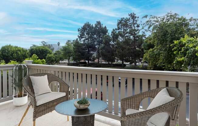 a balcony with two chairs and a table