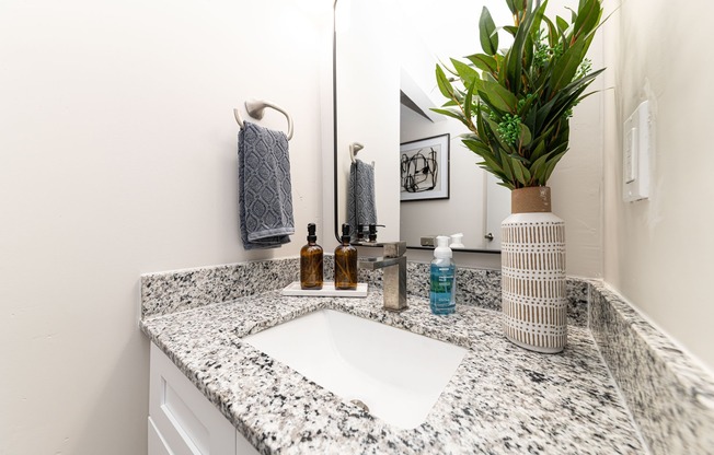 Bright bathroom with granite counters and high rise faucet