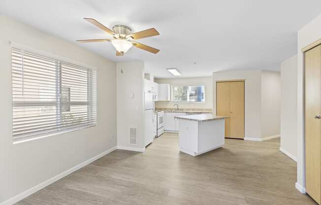 Spacious kitchen and living room with a large window and a ceiling fan at Promenade at the Park Apartment Homes, Washington, 98125