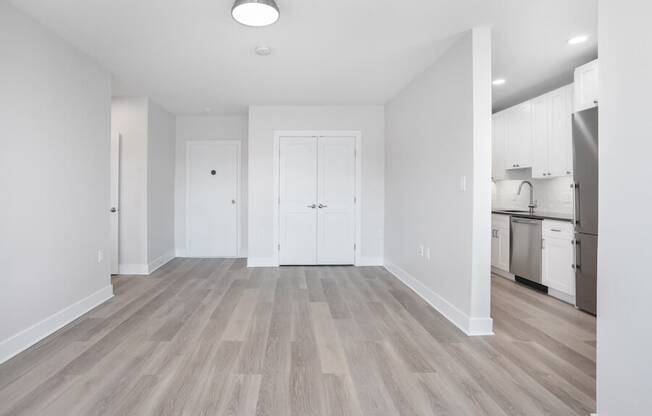 empty living room with a kitchen in the background