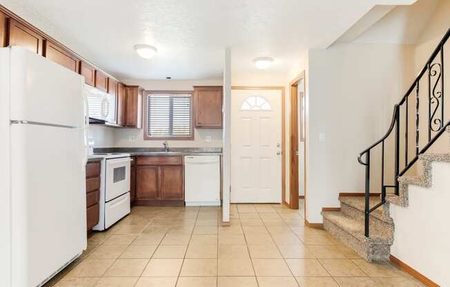 a kitchen with a white refrigerator freezer next to a stove top oven