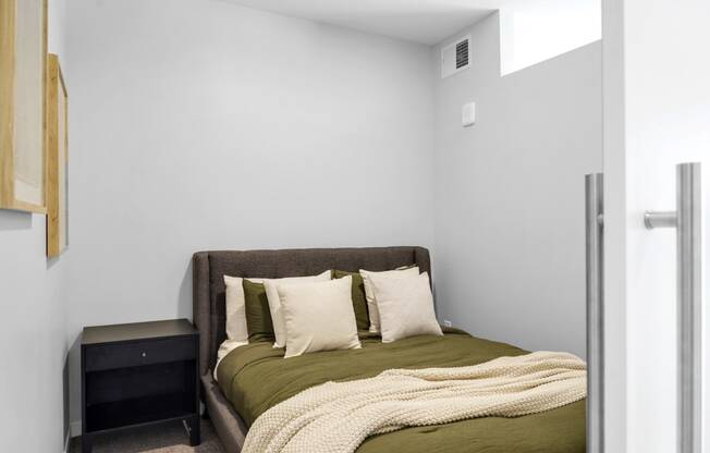 a bedroom with a bed and a nightstand in a 555 waverly unit