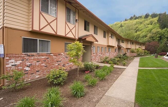 a row of apartments with a sidewalk and landscaping