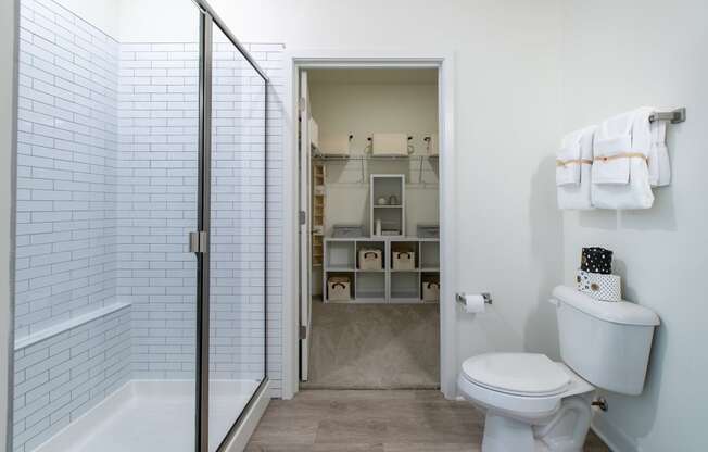 a bathroom with a white toilet and a shower with a glass door