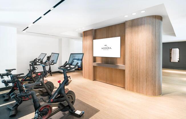 Peloton studio with connected bikes and wood-accented finishes, offering a sleek, energizing space for your daily ride.