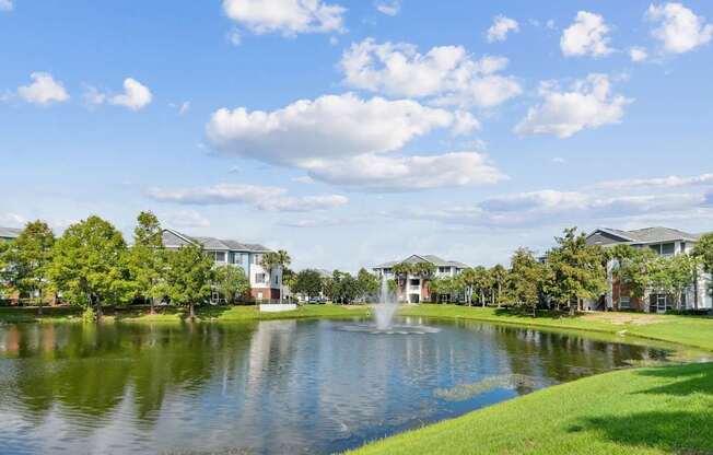 A serene pond surrounded by lush greenery at Wynnfield Lakes Apartments in Jacksonville, FL