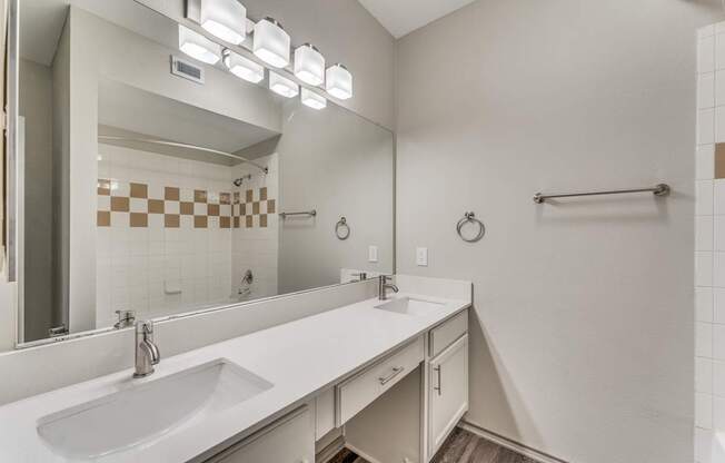 A bathroom with a white sink and a mirror.
