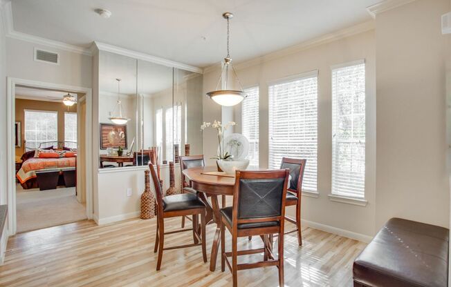 View of Dining Area with Hanging Light, Plank-Wood Flooring, and Décor at Raveneaux Apartments