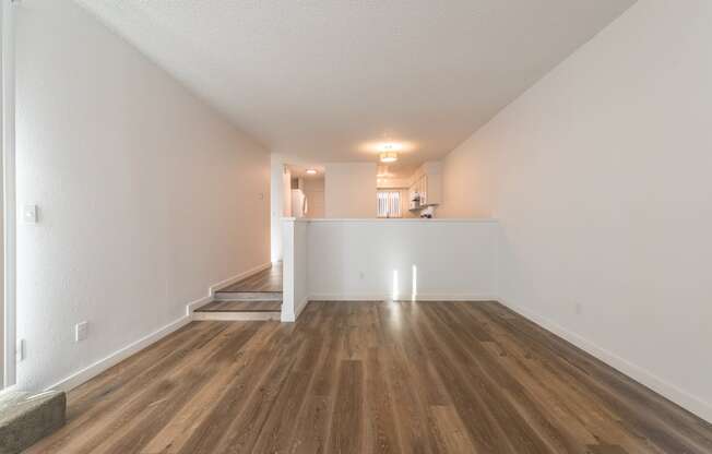 a bedroom with hardwood floors and white walls
