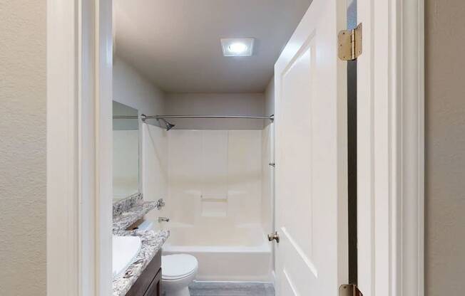 A bathroom with a toilet, sink, and bathtub.