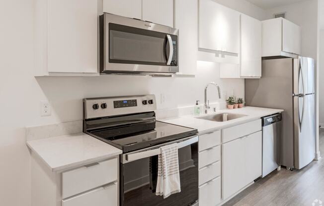 a kitchen with white cabinets and stainless steel appliances and a microwave