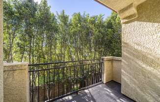 balcony with iron fence looking out to green trees at The Village Apartments, Van Nuys