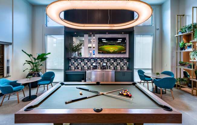 a pool table in a room with a bar and a television