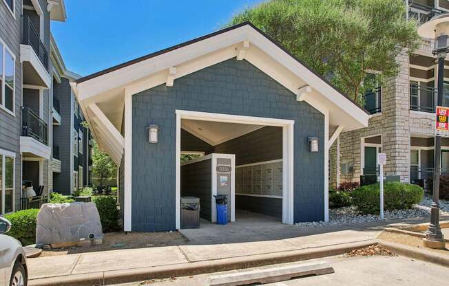 A modern two-story building with a garage door open.