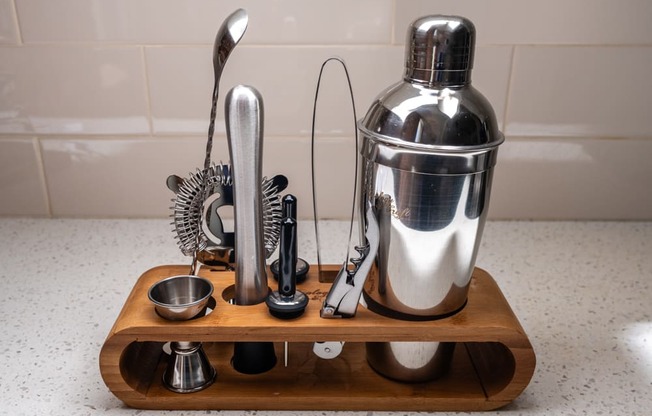 a wooden cutting board with various kitchen utensils on a kitchen counter