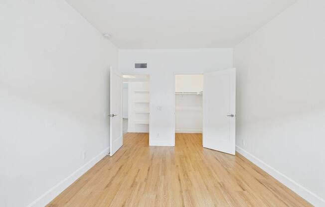 A long hallway with white walls and wood floors.
