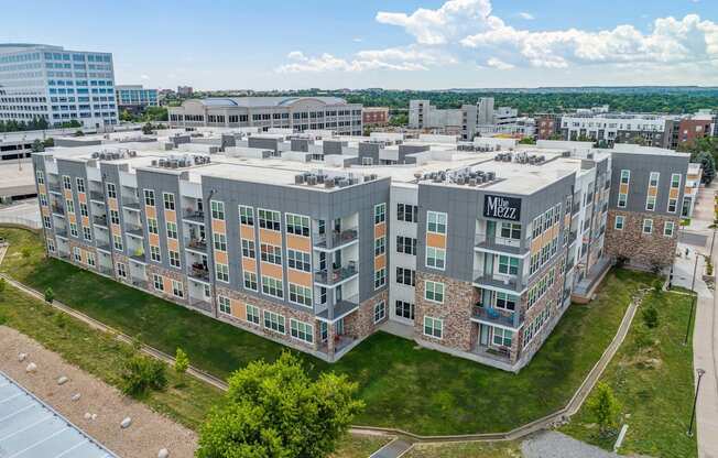 a large building with many windows and a grassy area in front of it