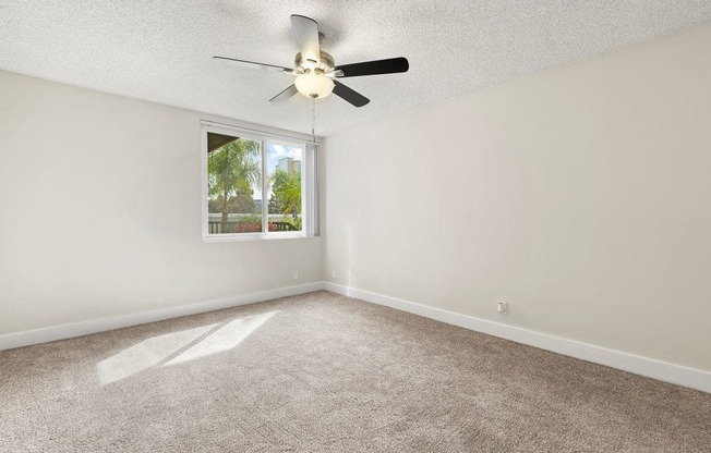 Apartments In Culver City, CA For Rent - Parkway Plaza - Spacious Bedroom With Floor Carpeting, Window For Natural Sunlight, And Ceiling Fan